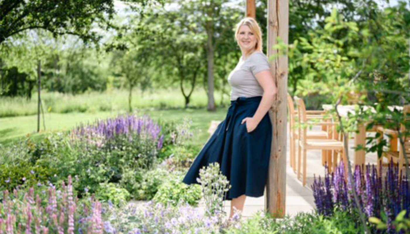 Tereza Antošová stojící v rozkvetlé zahradě